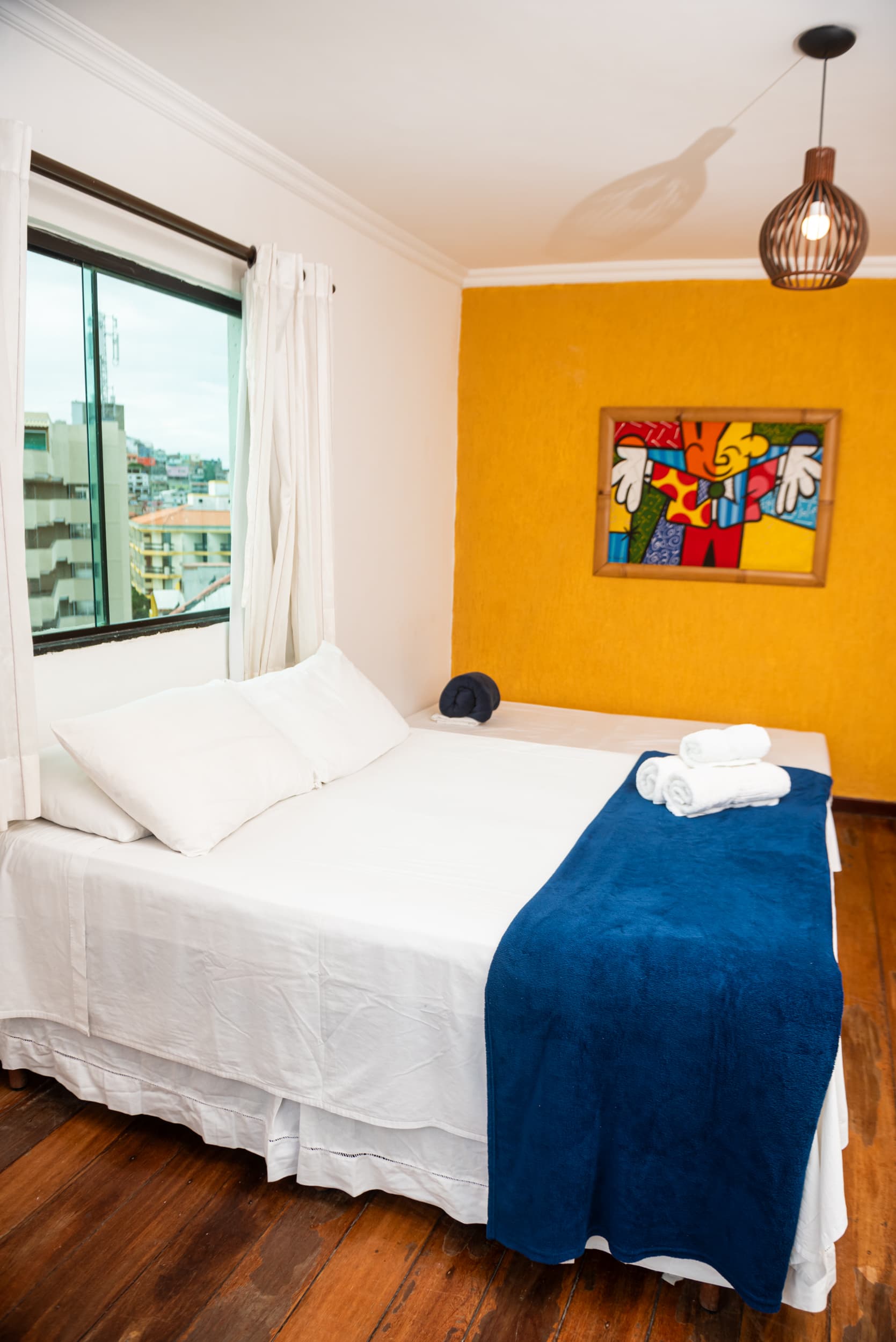 Ponta Leste - Amor à primeira vista. A janela revela um dos pores do sol mais bonitos do Brasil, criando uma atmosfera leve e encantadora. Com decoração minimalista e iluminação natural, o ambiente transmite simplicidade e charme, em perfeita harmonia com a beleza natural de Arraial do Cabo.